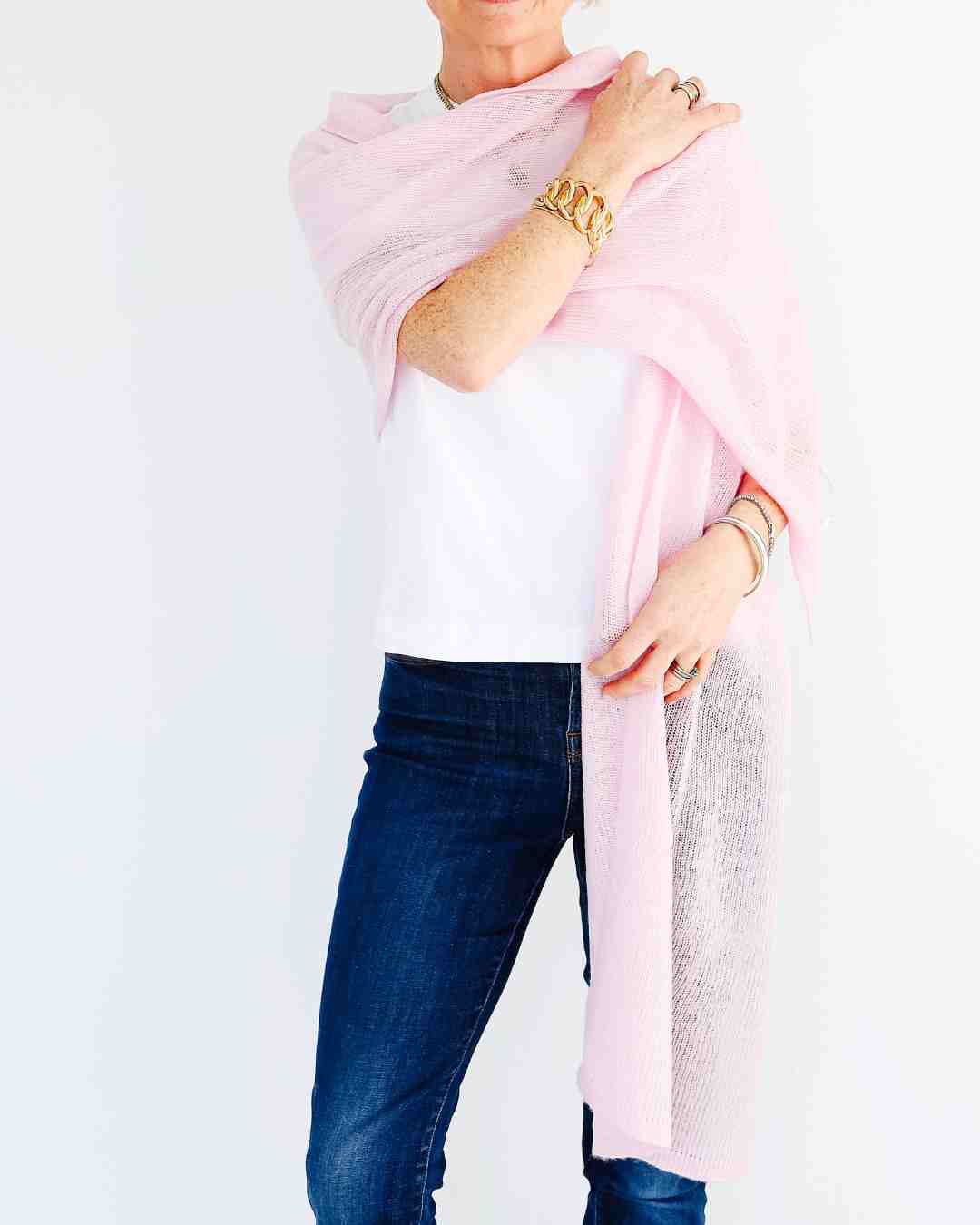 Woman wearing extra large peony pink cashmere scarf styled as elegant wrap Ireland