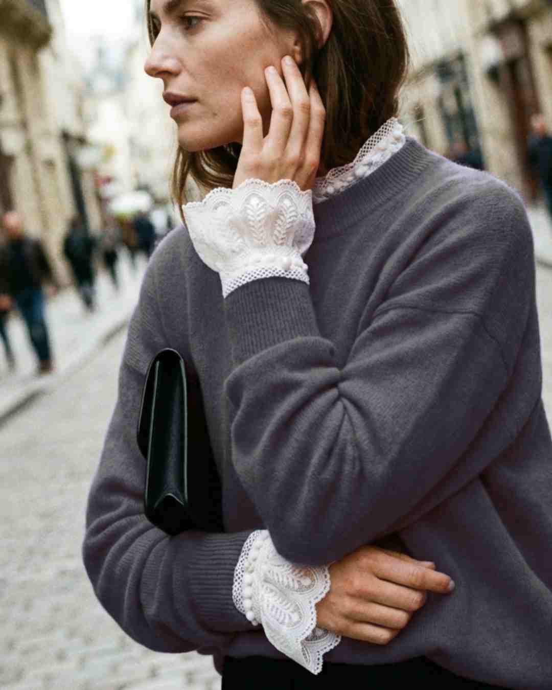 Layered outfit with detachable lace shirt cuffs peeking from under sweater sleeves – chic styling for women