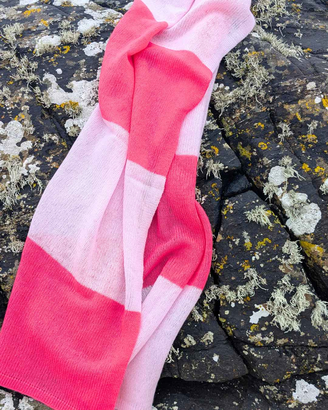 Pink and white striped sock on rocks in Ireland