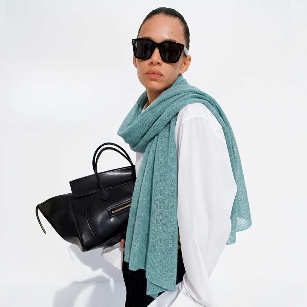 Woman styled in a lightweight sage green cashmere scarf designed in Ireland